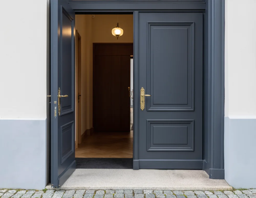 The step-free navy entrance door of the practice standing open onto the pavement of the Hoyerswerdaer Strasse.